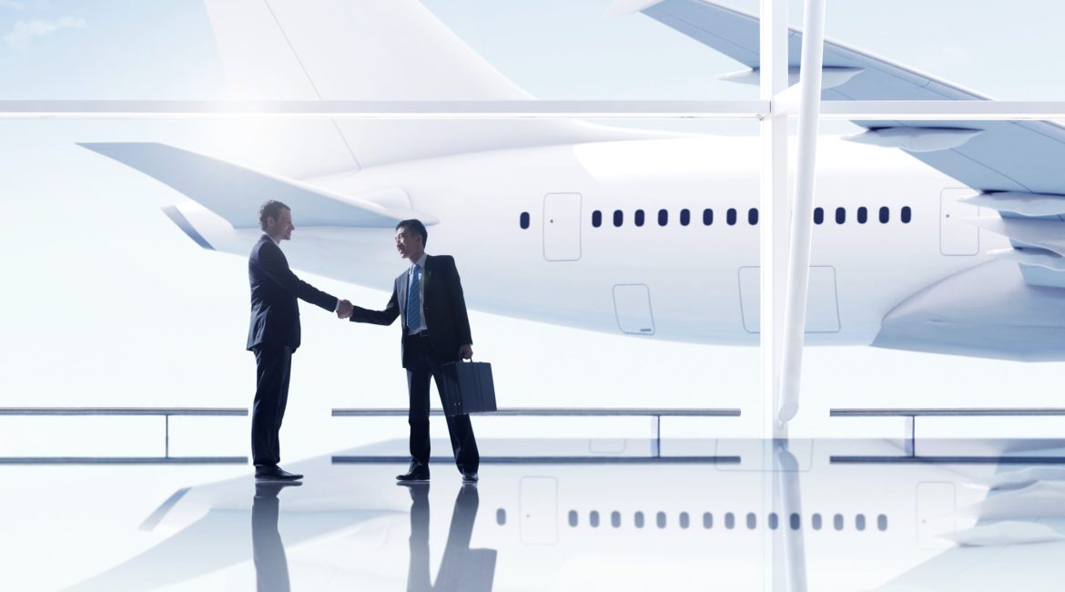 Western and asian businessmen handshake airport meeting Western and asian businessmen handshake airport meeting