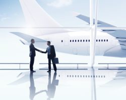 Western and asian businessmen handshake airport meeting